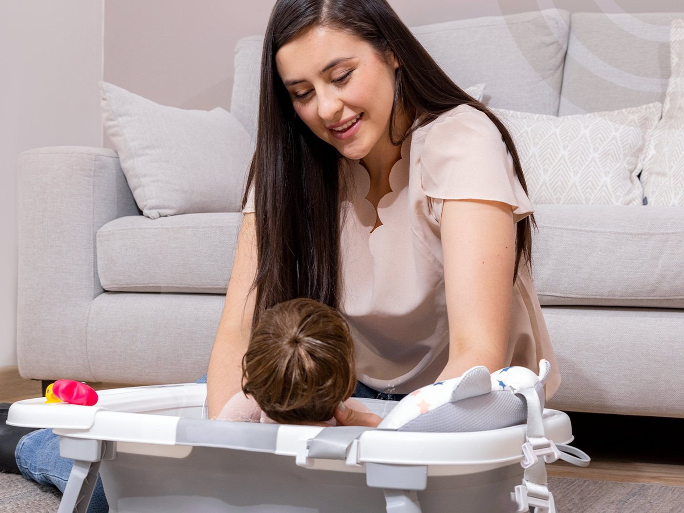 Maman qui donne le bain à son bébé dans la baignoire pliable