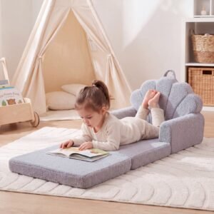 Fillette lisant allongée sur le fauteuil enfant gris déplié - Jolly Mino